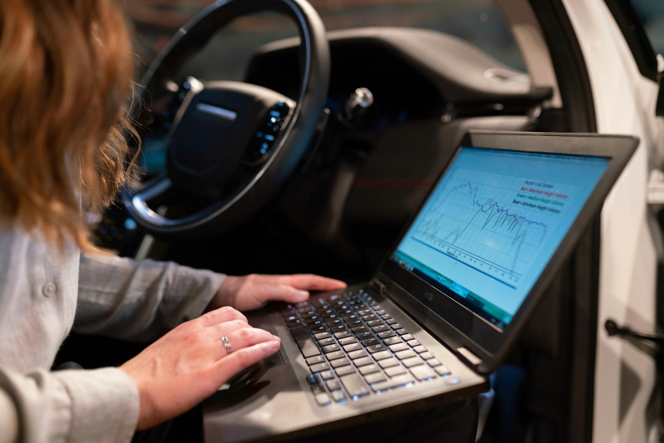 Diagnostyka komputerowa samochodu – mechanik z laptopem w kabinie pojazdu