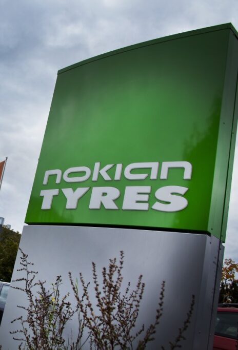 Zielony szyld Nokian Tyres przy drodze na tle zachmurzonego nieba