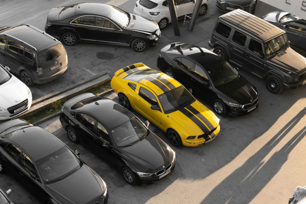 Różne samochody osobowe zaparkowane na parkingu — widok z góry