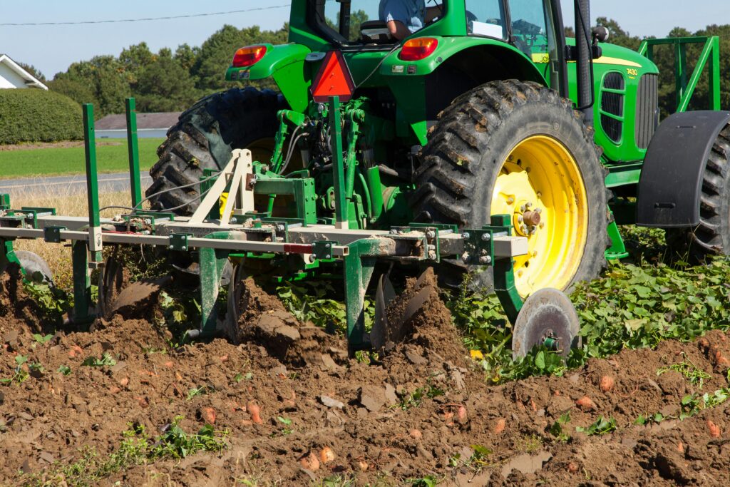 Zielony traktor John Deere pracujący na polu uprawnym