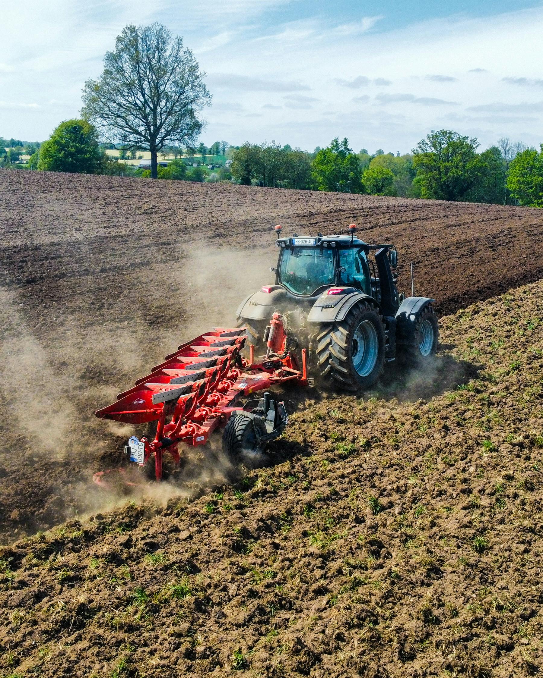 Traktor orający pole wiosną — pojazd rolniczy