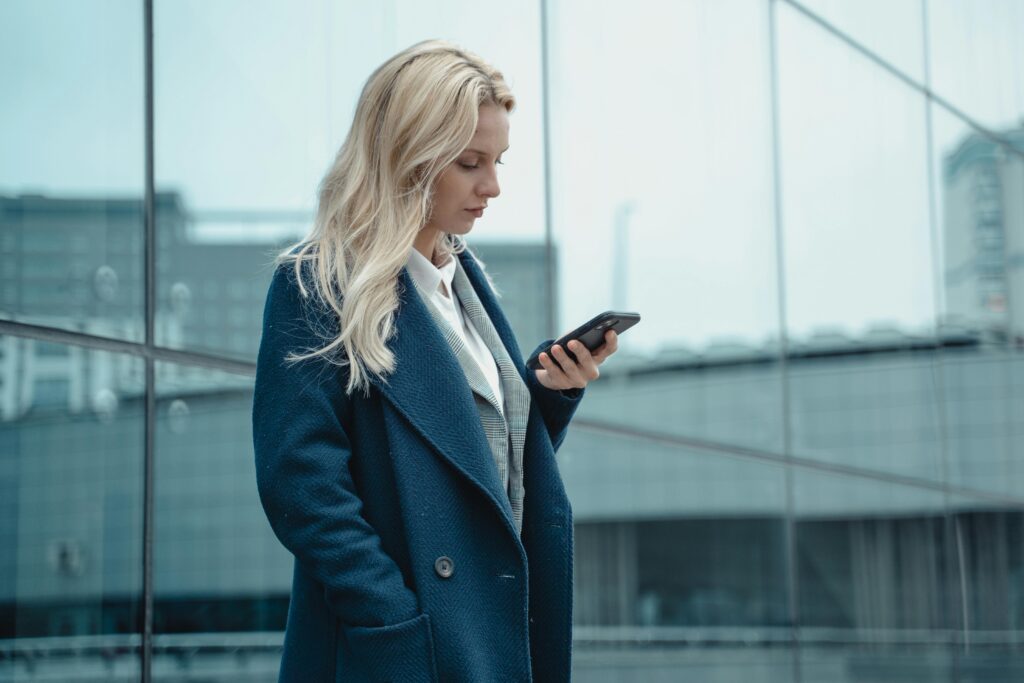 Kobieta z telefonem – rezerwacja wizyty w serwisie opon online