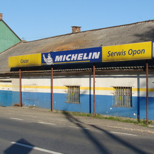 Front budynku warsztatu Cezar z banerem Michelin Serwis Opon, Inwałd