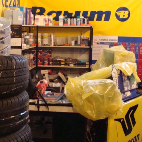 Stos opon i felg w warsztacie Cezar, banery Barum i Goodyear, Inwałd Andrychów