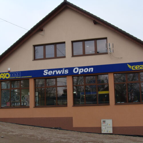 Zbliżenie na szyld Serwis Opon Cezar i logo ASO MAX na fasadzie budynku